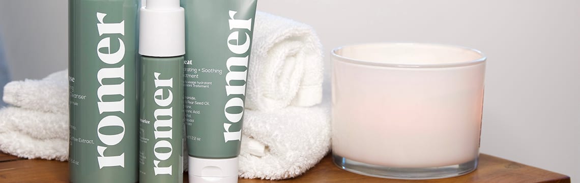 Romer Group Lifestyle Romer Skincare products next to a towel and a candle